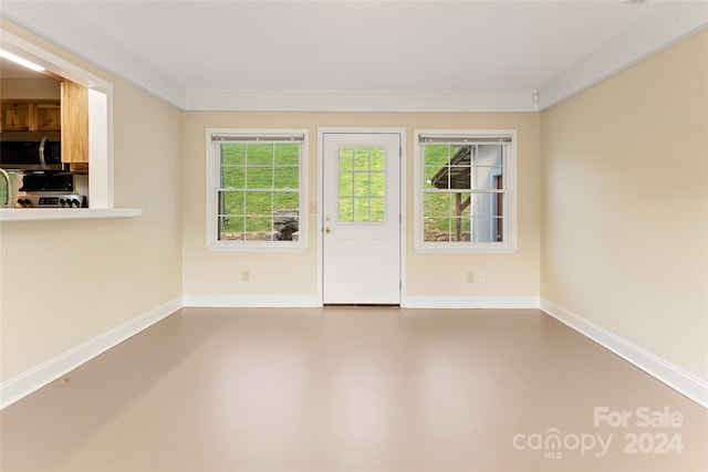 empty room with ornamental molding and concrete flooring