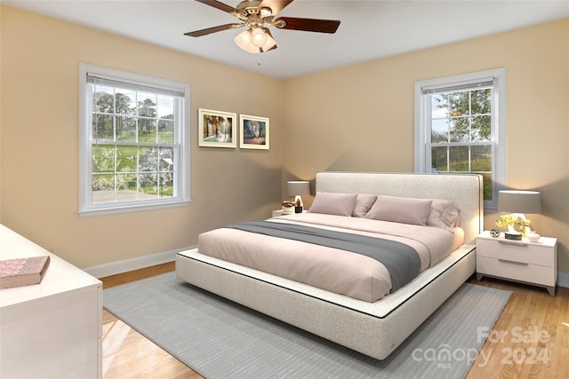 bedroom with multiple windows, light hardwood / wood-style floors, and ceiling fan