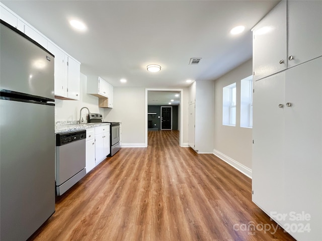 kitchen featuring light hardwood / wood-style floors, white cabinetry, stainless steel appliances, and sink