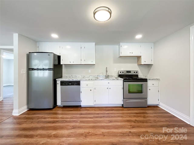 kitchen featuring sink, appliances with stainless steel finishes, hardwood / wood-style flooring, and white cabinetry