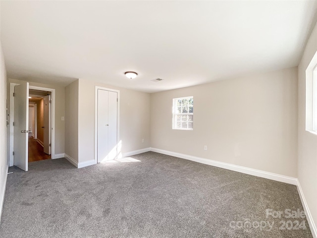 unfurnished bedroom with a closet and carpet flooring