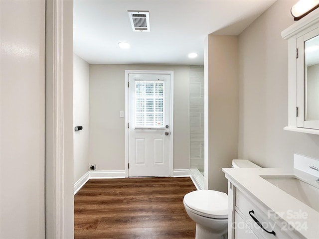 bathroom with vanity, toilet, wood-type flooring, and a shower