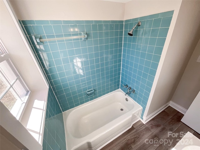 bathroom with tiled shower / bath combo and wood-type flooring