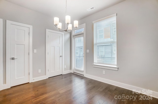 unfurnished room featuring dark hardwood / wood-style floors and a notable chandelier