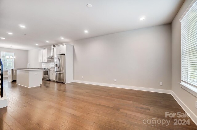 unfurnished living room with hardwood / wood-style floors and sink