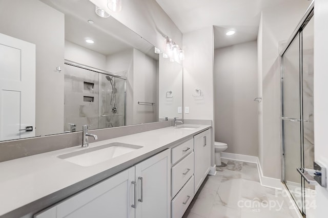 bathroom with vanity, a shower with shower door, and toilet