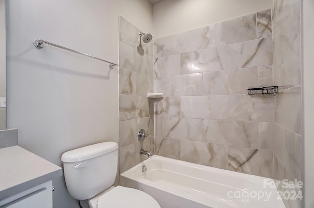 full bathroom featuring vanity, tiled shower / bath combo, and toilet