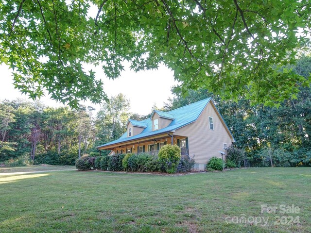 view of home's exterior featuring covered porch and a lawn