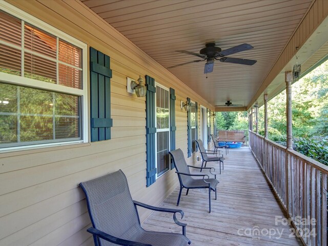 wooden deck featuring a porch and ceiling fan