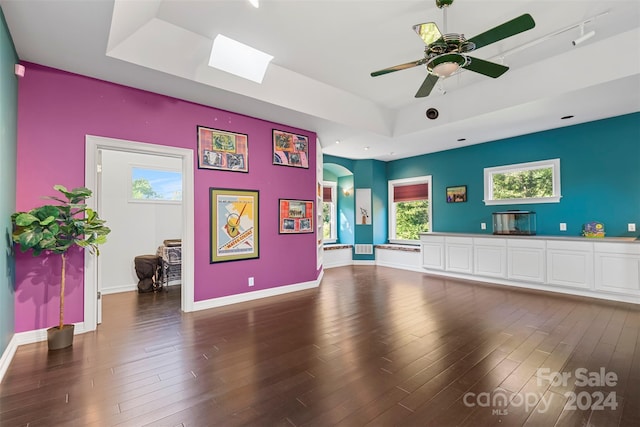 interior space featuring ceiling fan, dark hardwood / wood-style floors, and a tray ceiling