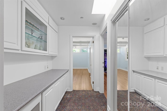 kitchen with dark hardwood / wood-style flooring and white cabinets