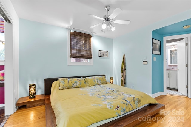 bedroom featuring ceiling fan, light hardwood / wood-style floors, and ensuite bathroom