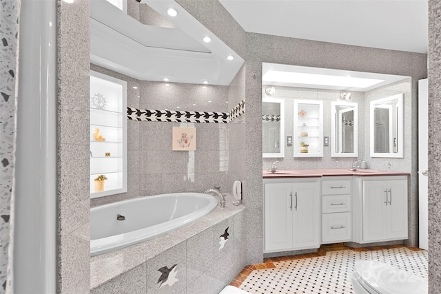 bathroom with vanity, tile patterned flooring, crown molding, and a relaxing tiled tub