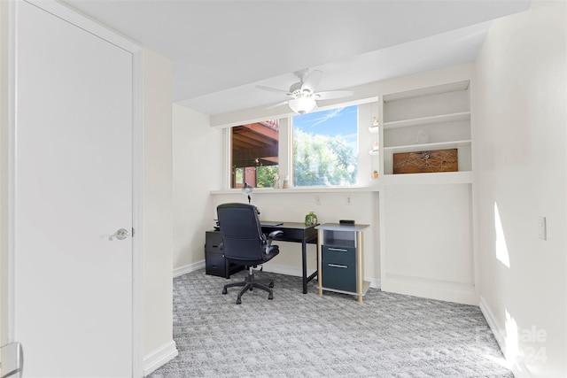 carpeted office space with ceiling fan