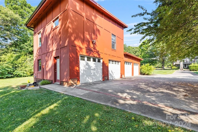 view of side of property with a yard and a garage