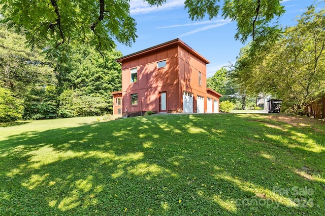 back of house with a yard and a garage