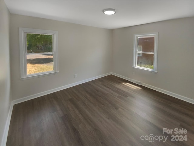 unfurnished room with a wealth of natural light and dark hardwood / wood-style floors