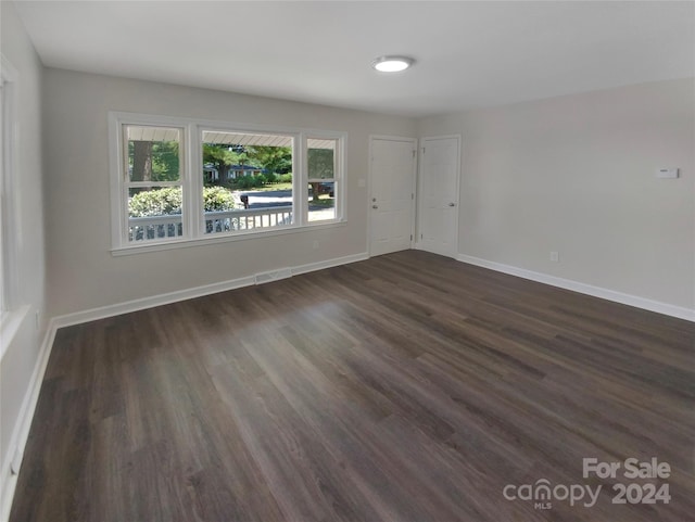 unfurnished room featuring dark wood-type flooring