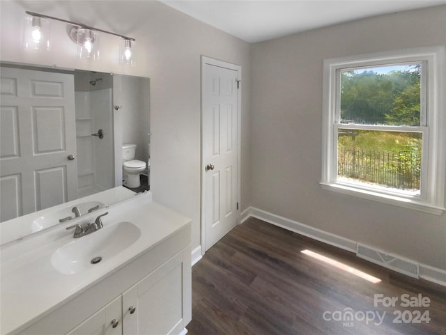 bathroom with walk in shower, vanity, wood-type flooring, and toilet