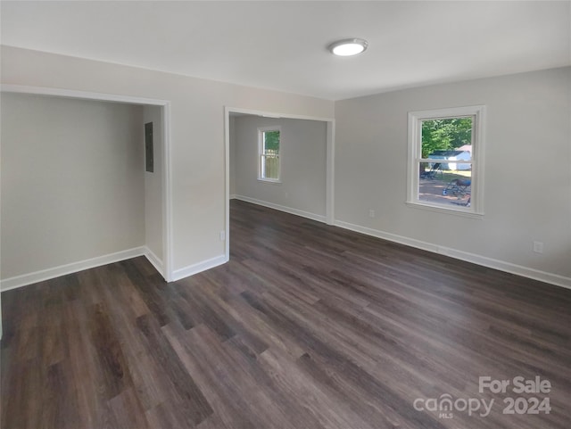 spare room with dark hardwood / wood-style flooring and plenty of natural light