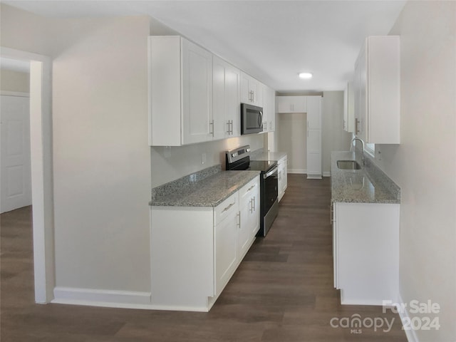 kitchen featuring sink, white cabinetry, light stone countertops, appliances with stainless steel finishes, and dark wood-type flooring