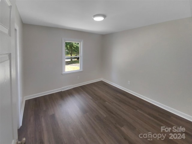 spare room with dark hardwood / wood-style flooring