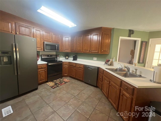 kitchen featuring light tile patterned floors, sink, and stainless steel appliances