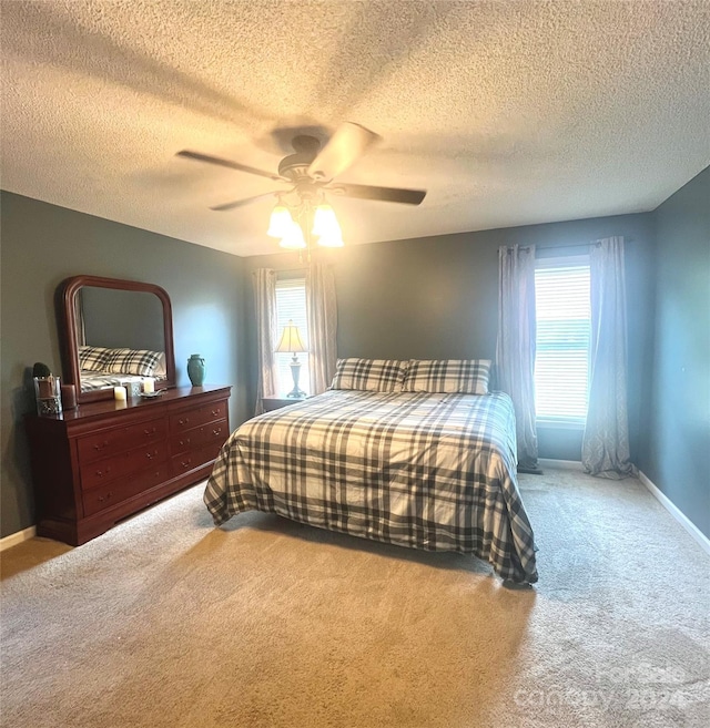 bedroom featuring ceiling fan, a textured ceiling, and carpet flooring