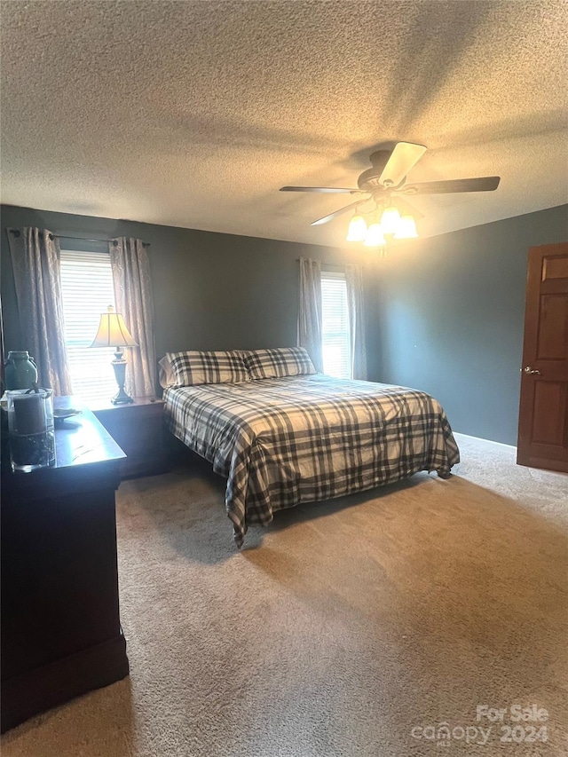 carpeted bedroom featuring a textured ceiling and ceiling fan