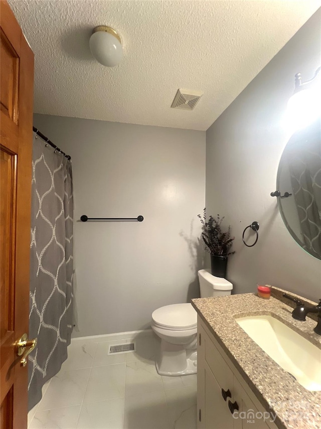 bathroom with a textured ceiling, toilet, and vanity