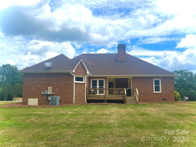 rear view of property with a wooden deck, cooling unit, and a yard