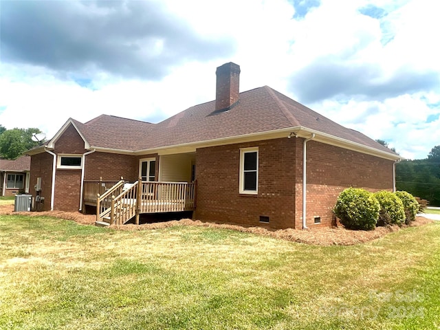 rear view of house with a lawn, central AC unit, and a wooden deck