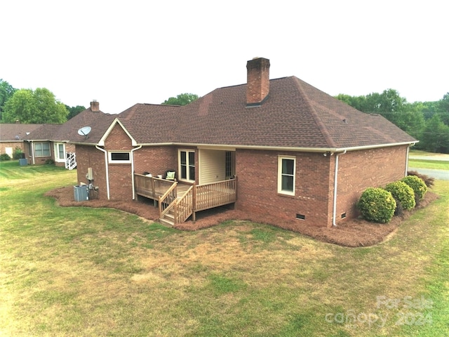 back of property with a deck, a yard, and central air condition unit