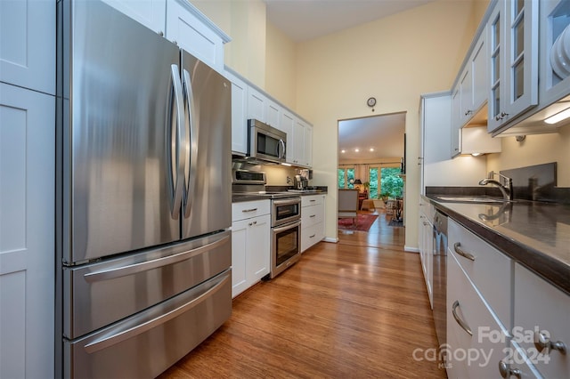 kitchen featuring white cabinetry, appliances with stainless steel finishes, sink, and light hardwood / wood-style flooring