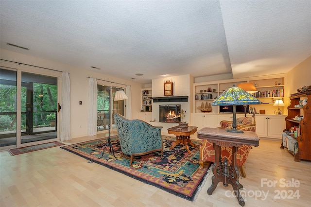 living room featuring light hardwood / wood-style floors and a textured ceiling