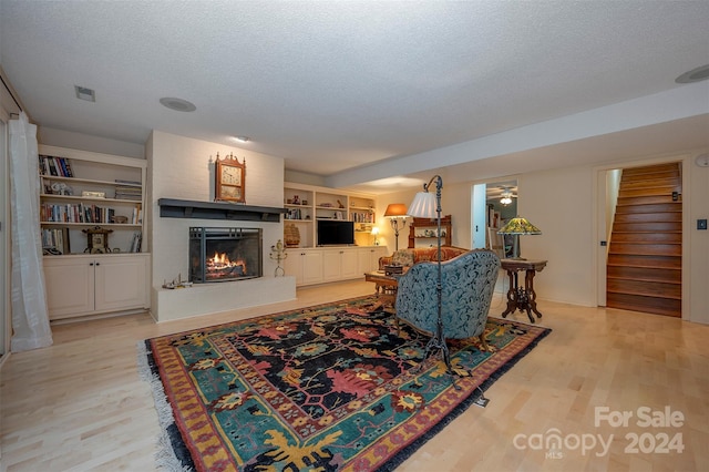 living room with a textured ceiling and light wood-type flooring