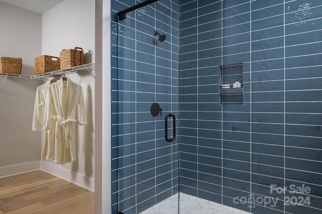 bathroom featuring walk in shower and wood-type flooring