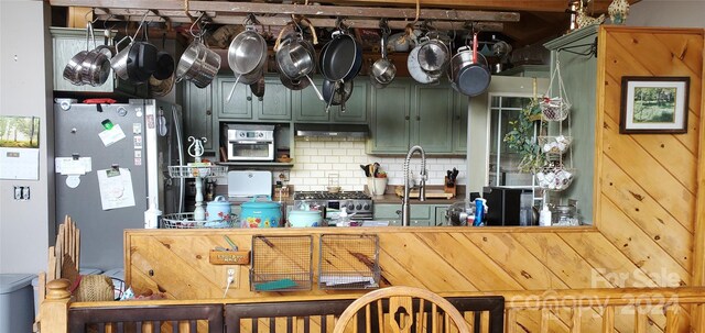 kitchen featuring stainless steel appliances, decorative backsplash, and green cabinets