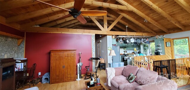 living room with beamed ceiling, wooden ceiling, high vaulted ceiling, hardwood / wood-style flooring, and ceiling fan