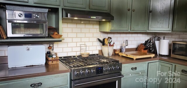 kitchen featuring backsplash, appliances with stainless steel finishes, and green cabinets