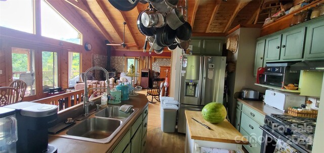 kitchen featuring wood-type flooring, wood ceiling, stainless steel appliances, green cabinetry, and vaulted ceiling with beams