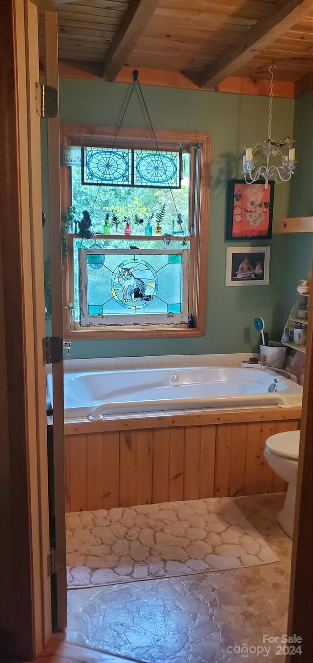 bathroom featuring beam ceiling, wood ceiling, toilet, a chandelier, and a washtub