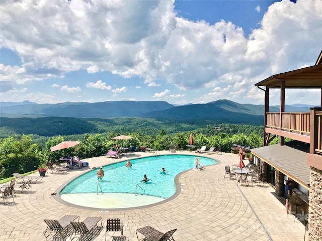 view of pool with a mountain view and a patio