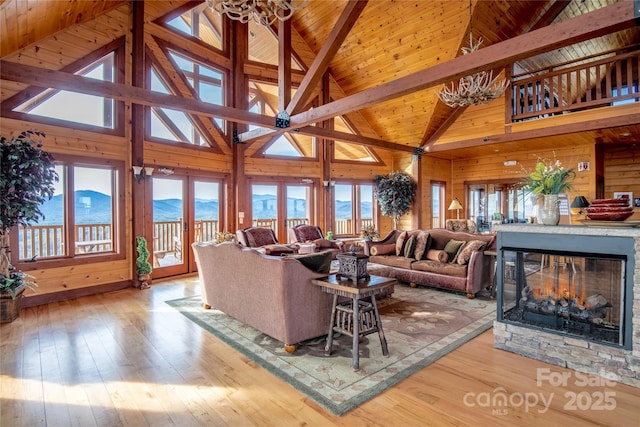 living area with plenty of natural light, wood walls, wooden ceiling, and hardwood / wood-style flooring