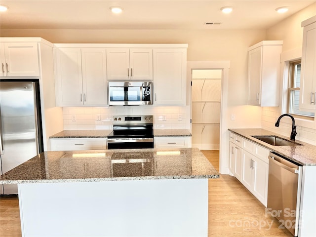 1387 River Club Rdg, Lenoir, NC 28645 - kitchen featuring visible vents, a sink, stone countertops, light wood-style floors, and appliances with stainless steel finishes