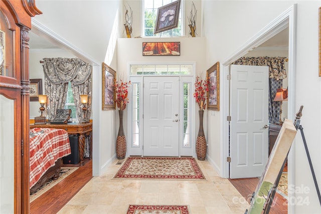 foyer featuring a high ceiling and crown molding