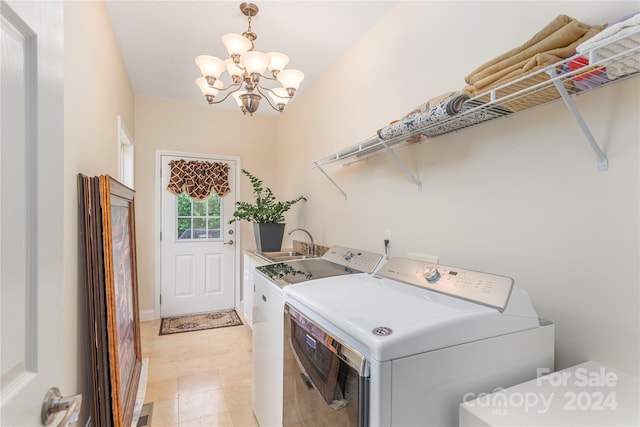 washroom with an inviting chandelier, separate washer and dryer, and sink