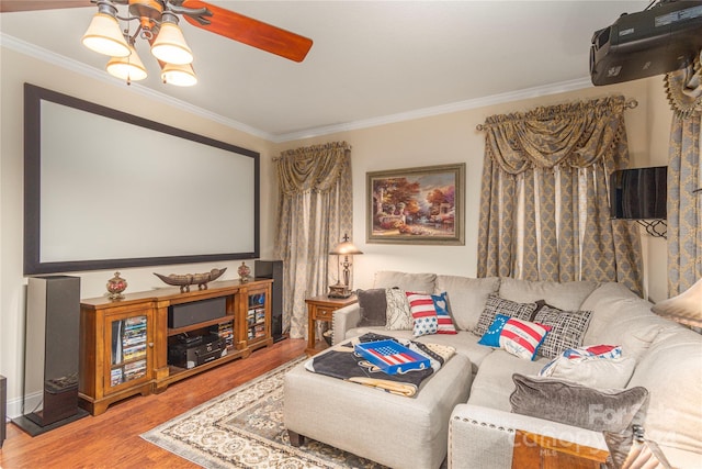 home theater room featuring hardwood / wood-style floors, ceiling fan, and ornamental molding