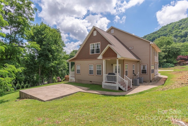 rear view of property with a patio and a lawn