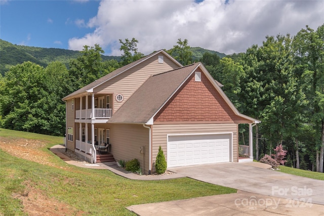 view of front of home with a balcony, a garage, and a front lawn